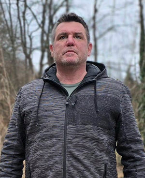 Person standing outdoors in a gray jacket